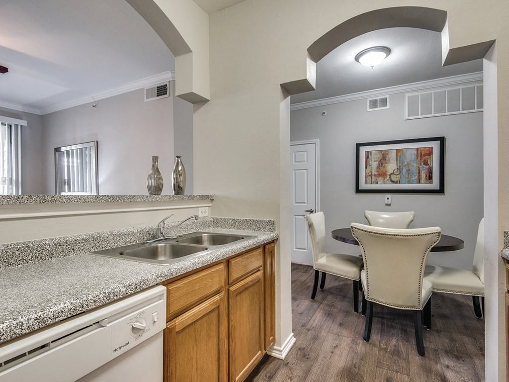 The kitchen leading into the dining room at the Kensley Apartment Homes in Irving, Texas.